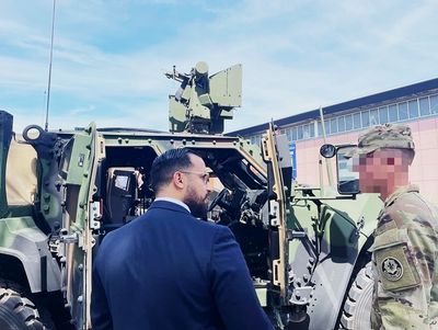 Alexandre Benalla with a U.S. Army officer alongside military vehicles